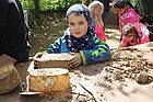 Mehrere Kinder backen mit Sand, ein Junge hat eine Eisdose als Form benutzt.