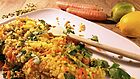 Gelber Reis mit buntem Gemüse auf einem Teller